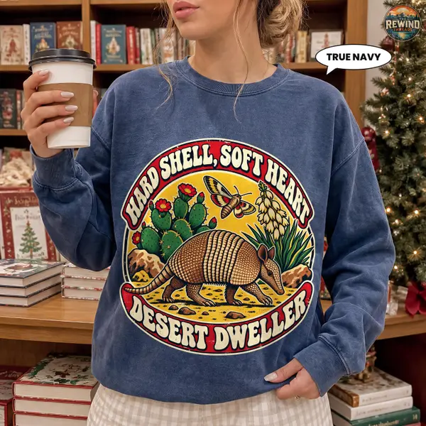 Model wearing a True Navy crewneck sweatshirt with a colorful armadillo desert badge featuring cactus, moth and Hard Shell, Soft Heart and Desert Dweller text.