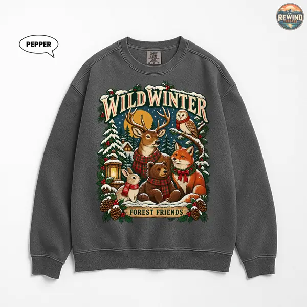 Watermelon pink crewneck sweatshirt shown flat, printed with a Wild Winter forest scene of a deer, owl, fox, bear cub and rabbit in a snowy wood with a lantern.
